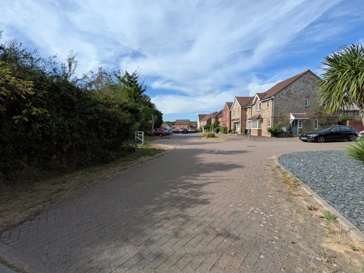 Wide-angle shot of a close of houses with cars parked out front