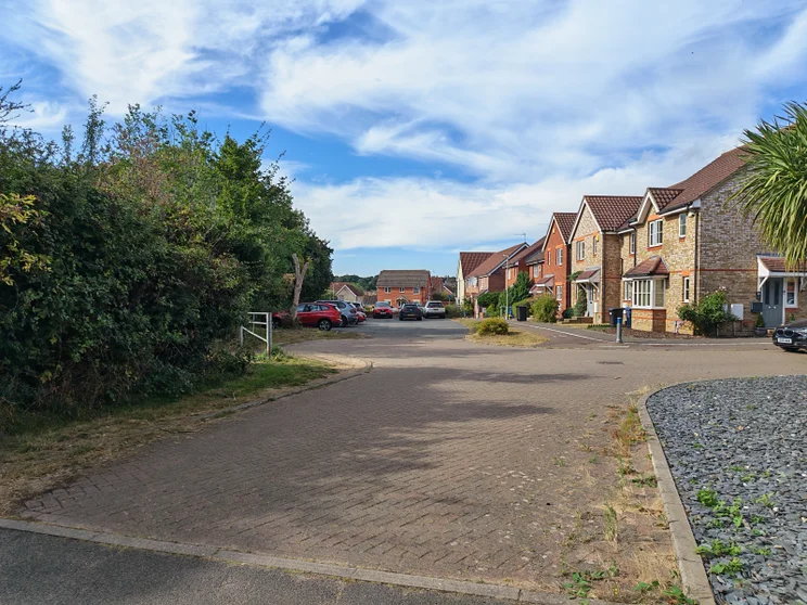 A quiet close of houses with cars parked out front