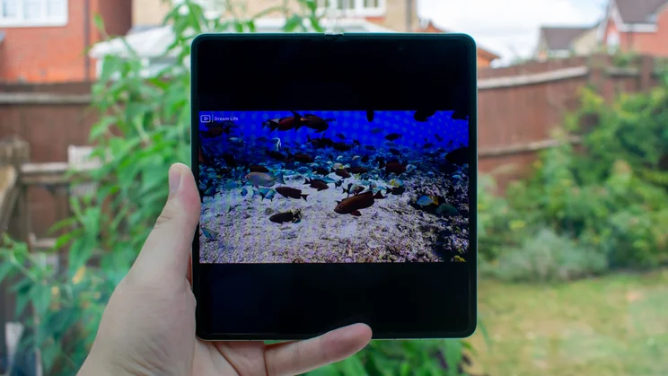 Honor Magic V5 unfolded in hand, with a video on the main display