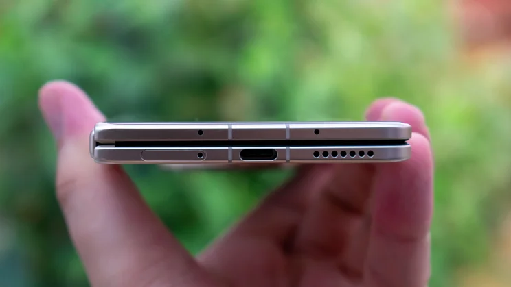 Honor Magic V5 folded in hand, showing the bottom edge and charging port