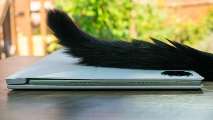 Huawei MatePad Pro (2025) folded in the case, side view, with a black cat tail draped across the top