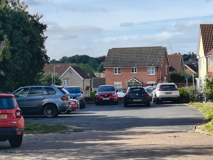 4x zoom of houses with cars out front