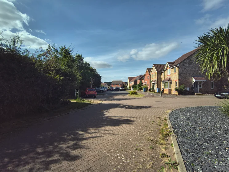 Wide-angle shot of a close of houses with cars parked out front