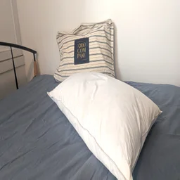 One Odd Company Luxury Pillow on a mattress with its carry bag behind it