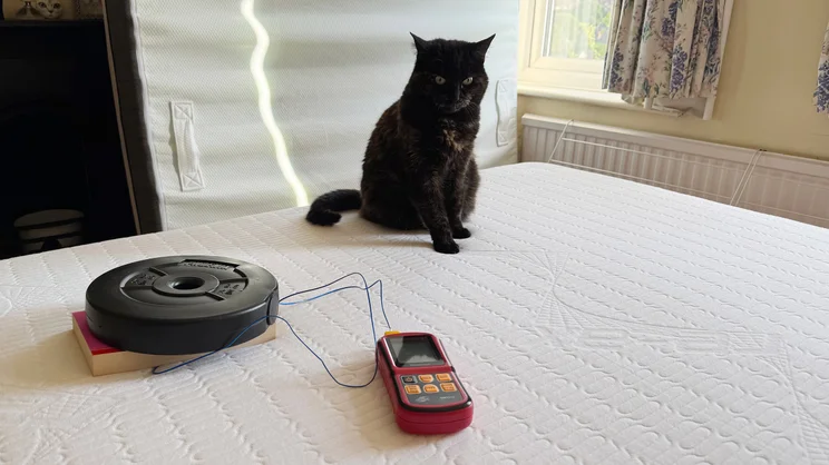 Testing temperature retention of the REM-Fit 600 Lux Elite mattress- using a 2.5kg weight, a book and a thermocouple. A cat watches on, looking cross