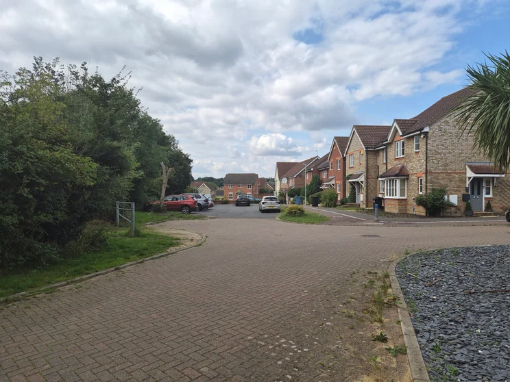 A quiet close of houses with cars parked out front