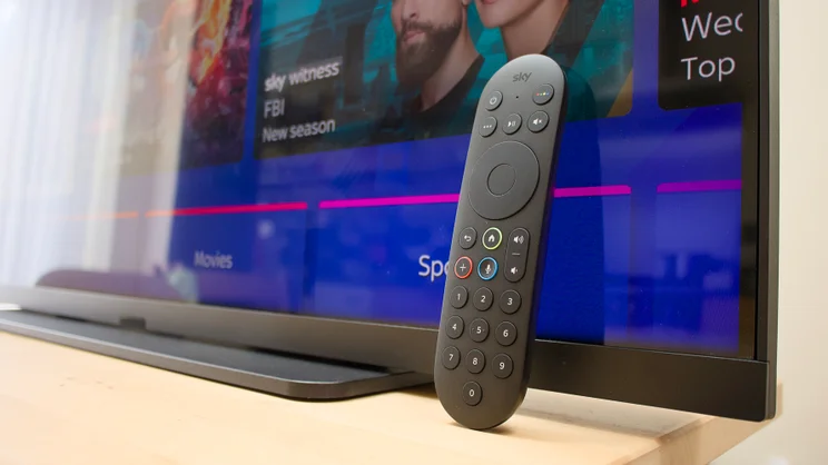 A close up of the Sky Glass Air's remote control leaning against the lower right hand corener of the TV