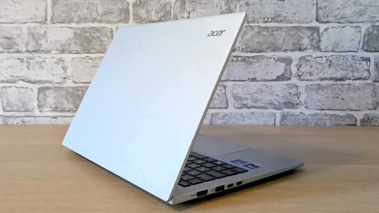 The Acer Aspire 14 AI laptop, half open, pictured from the rear left corner