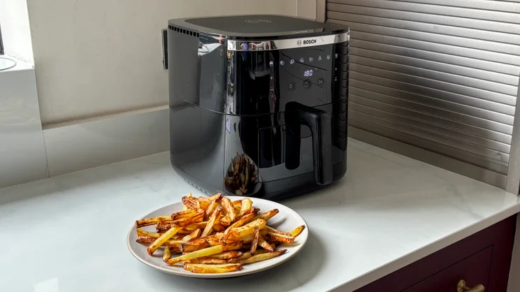 The Bosch Series 6 Air Fryer with a plate of cooked fries in front of it