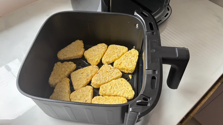 The Bosch Series 6 Air Fryer's cooking drawer with 12 frozen hash browns covering the bottom