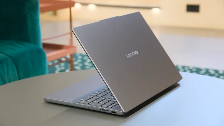 The Lenovo IdeaPad 3x 2025 half open, pictured from the rear right on a circular coffee table