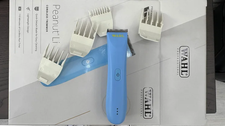 The Wahl Peanut Li cordless trimmer on top of its box, with attachments