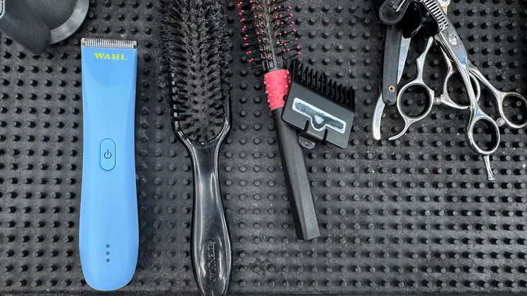 The Wahl Peanut Li cordless trimmer on a barber's worktop, surrounded by other tools