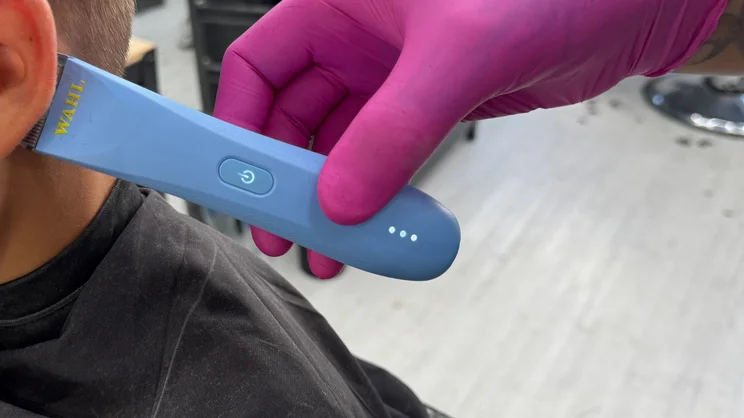 The Wahl Peanut Li cordless trimmer being used to trim hair behind the ear
