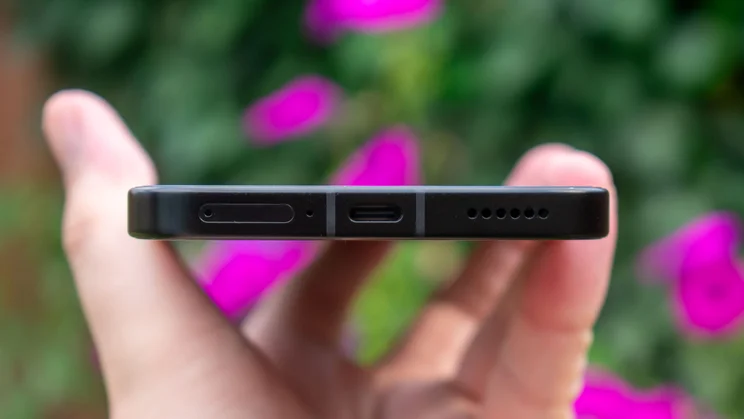 Xiaomi Poco F7 in hand, showing the bottom edge and charging port