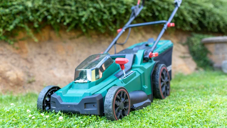 cordless mower parked on lawn