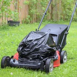 lawn power parked outside in rain, bin bag over motor