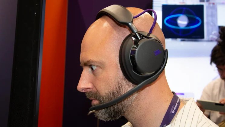 Side view of the JBL Quantum 950 wireless gaming headset being worn by a bald man with a beard