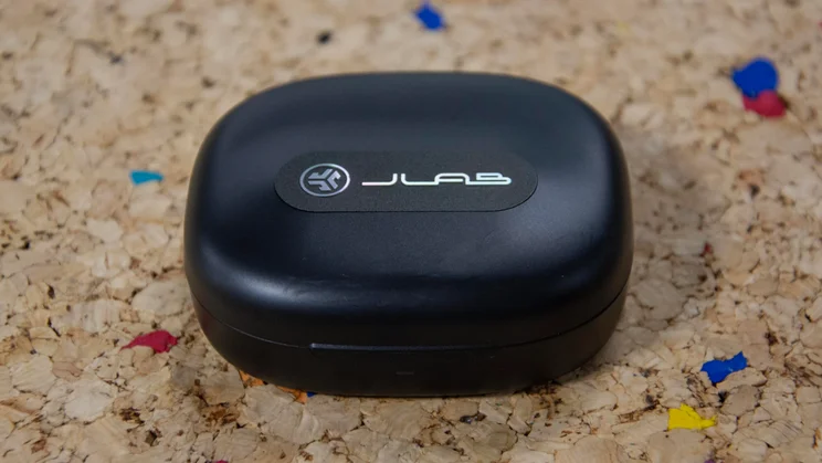 The JLab Epic Open Sport open-ear headphones' charging case closed on a cork table