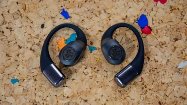 The JLab Epic Open Sport open-ear headphones laid flat on a cork table