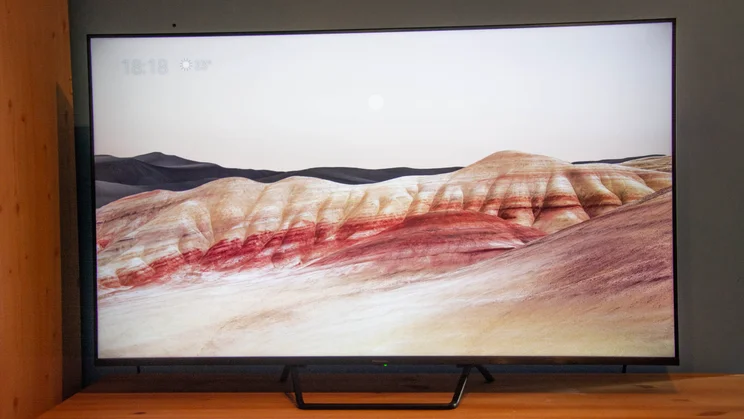 The Panasonic W95B Mini LED TV on a wooden cabinet displaying an image of moonlit dunes