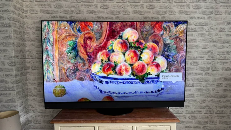 Front view of the Panasonic Z95B OLED displaying the Fire TV Ambient Experience screensaver "Still Life with Peaches"