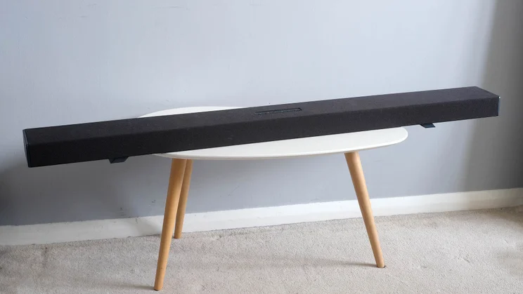 The Sharp-HT-SBW55121 soundbar facing forwards on a table with three wooden legs