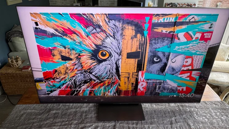 Aerial view of the TCL C8K QD-Mini LED TV on a kitchen table displaying a graffiti wallpaper