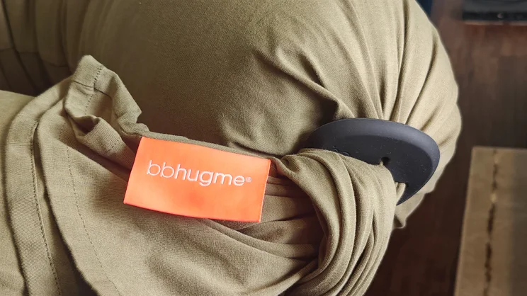 A closeup of the Bbhugme pregnancy pillow with brand label and "pebble" fastening