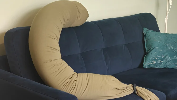 The Bbhugme pregnancy pillow on a blue sofa
