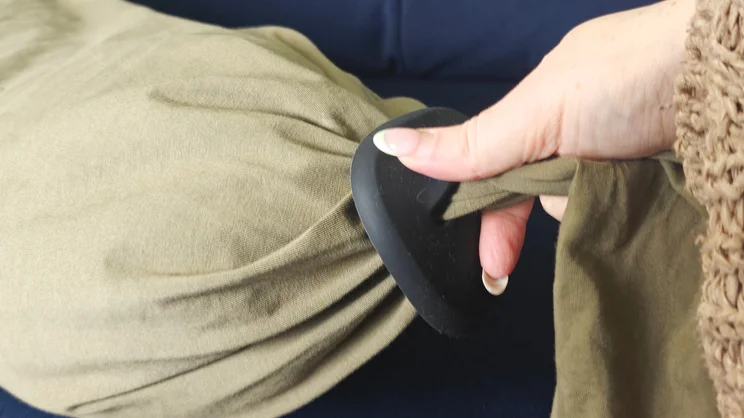 A hand tightening the "pebble" fastening on the Bbhugme pregnancy pillow