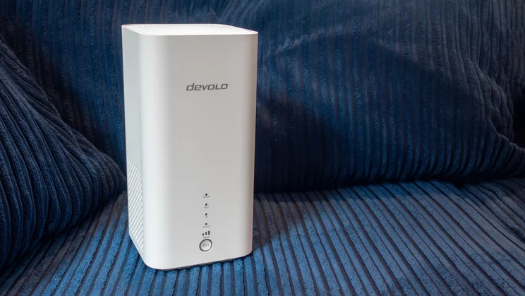 The Devolo 3600 5G shown from the front on a blue fabric background