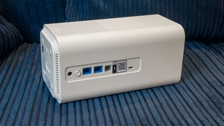 The Devolo 3600 5G shown on its side from the rear on a blue fabric background