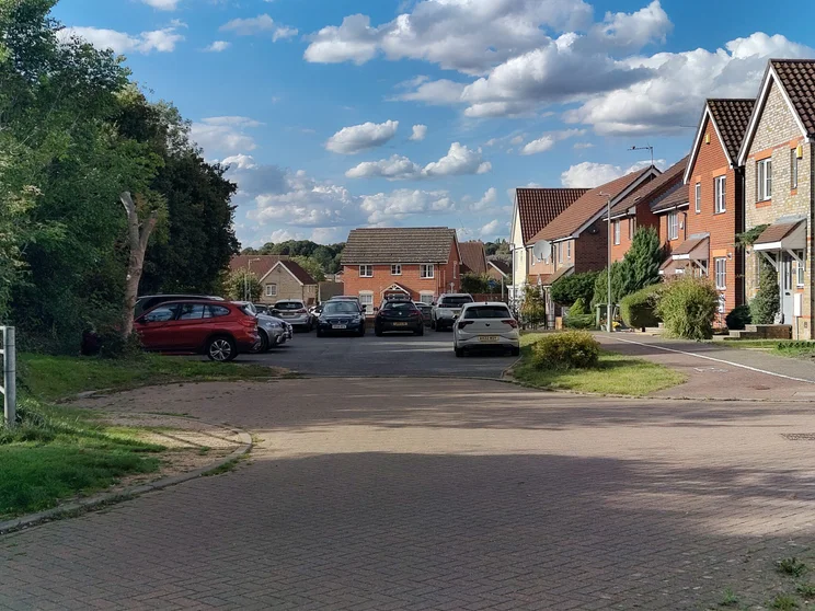 2x zoom of houses with cars parked out front