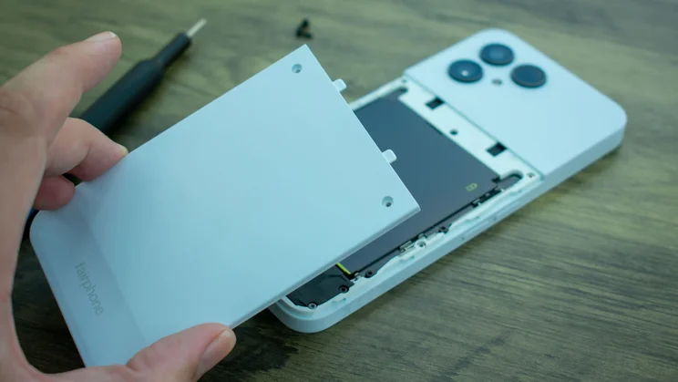 Hand removing the backplate of the Fairphone 6