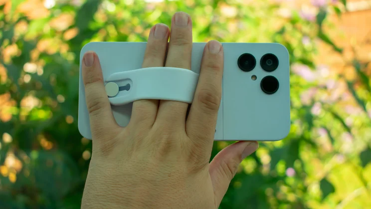 Hand holding Fairphone 6 with fingers through loop