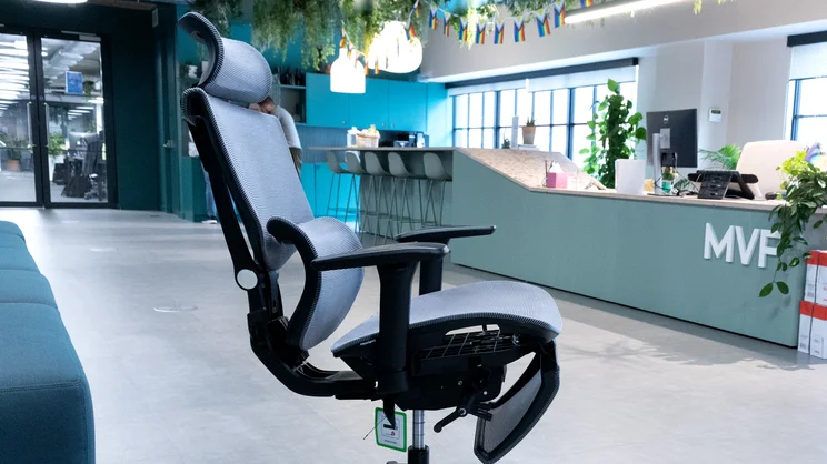 A side view of the Flexispot C7 office chair in an office, with backrest reclined