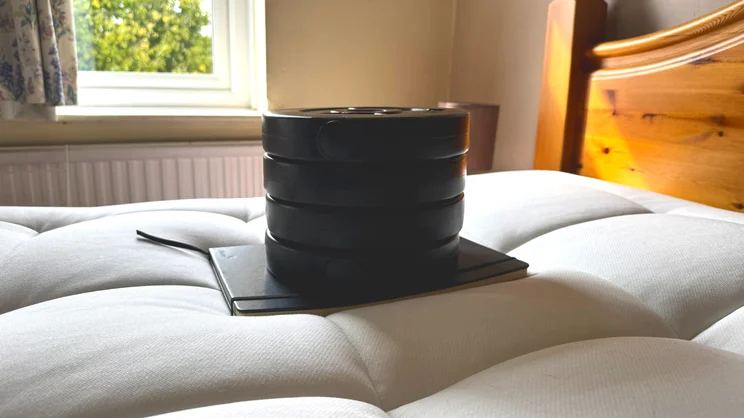 On the surface of the REM-Fit Natural Lux Hybrid mattress, a series of weights is being used to test sinkage