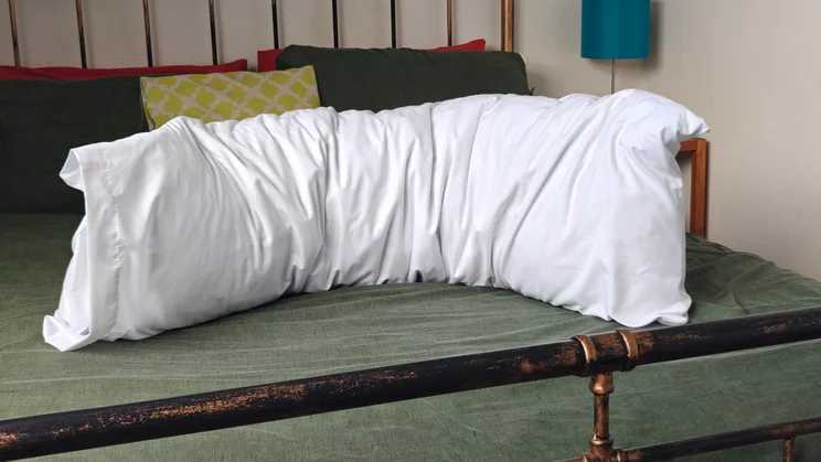 The Silentnight Body Support Pillow on a bed