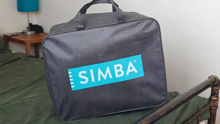 The carry bag for the Simba Body Pillow, on a bed