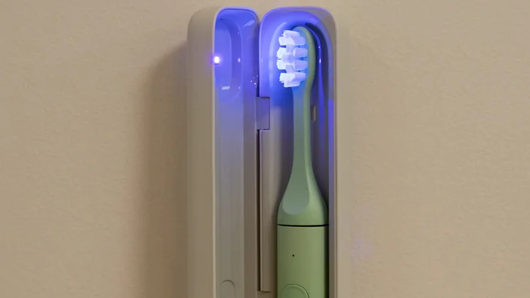 The Suri 2.0 electric toothbrush in its travel case, with UV cleaning light switched on