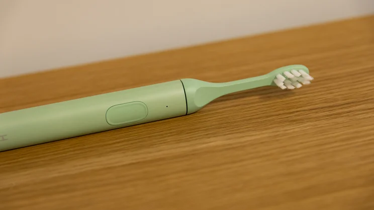 A closeup of the Suri 2.0 electric toothbrush lying on a table