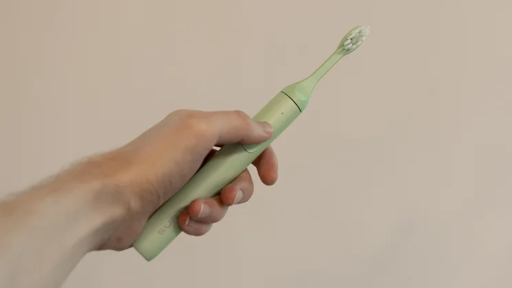 The Suri 2.0 electric toothbrush held in a hand