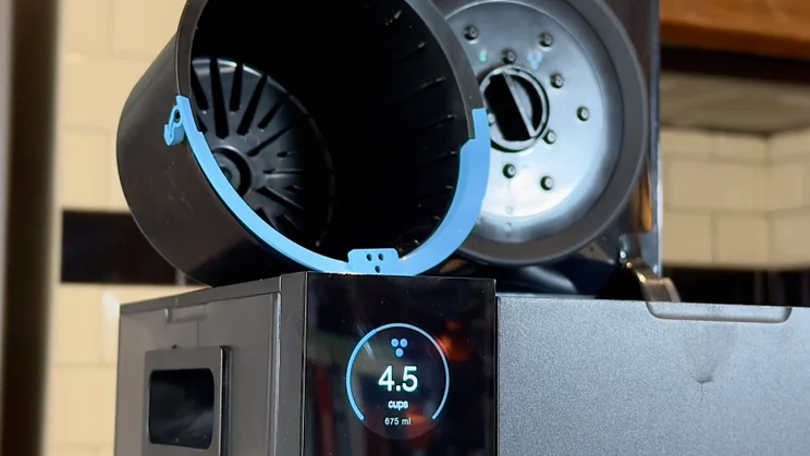 The Fellow Aiden coffee machine pictured with its larger blue-handled coffee basket