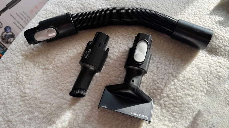 Attachments for the VAX HomePro Detect Pet-Design vacuum cleaner on top of a bed