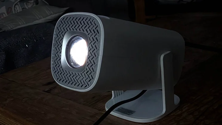The Acer AOPEN QH15s projector turned on and pointing to the left in a dark room