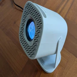 The Acer AOPEN QH15s projector on a wooden floor pointing to the left