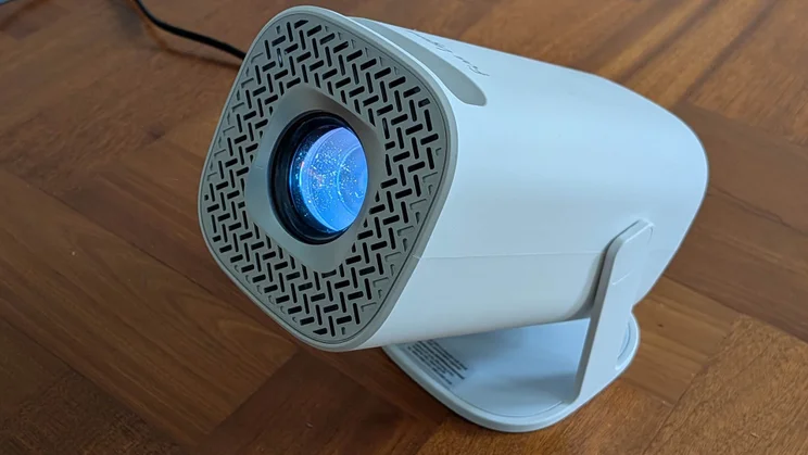 The Acer AOPEN QH15s projector on a wooden floor pointing to the left