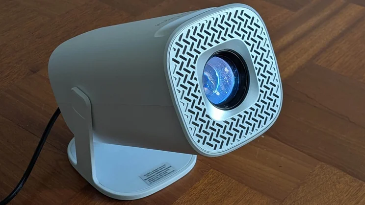 The Acer AOPEN QH15s projector on a wooden floor pointing to the right