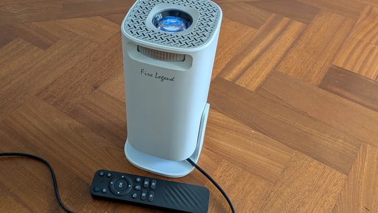 The Acer AOPEN QH15s projector pointing directly upwards to the ceiling with its remote control on the floor alongside it